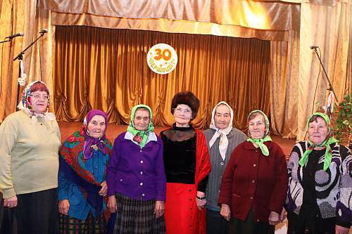 Singing group 'Pershotsvit' (primrose) from Kocherezhky village against the background of inscription '30 Years of group 'Pershotsvit' © Kravchenko Dmytro, 2014